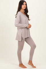 woman wearing a light taupe long sleeve tunic top with side slits and matching fitted leggings