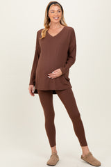 woman wearing a brown maternity top and matching leggings, showcasing her baby bump