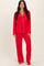 woman wearing a red long sleeve pajama set with white piping details