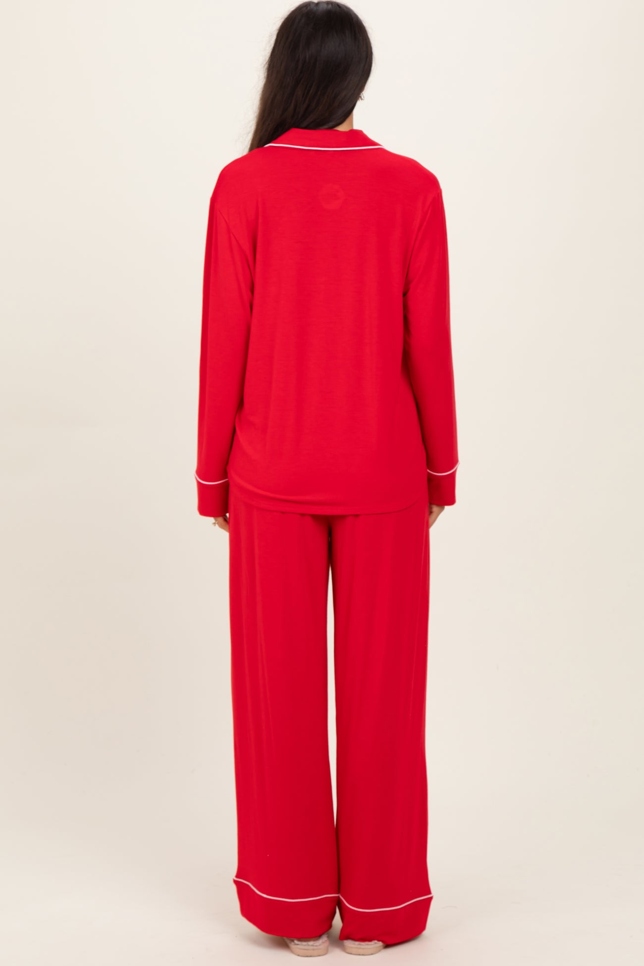 woman wearing a red long sleeve pajama set with matching wide-leg pants, seen from the back