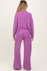 woman wearing a purple ribbed maternity lounge set with long sleeves and wide-leg pants, showing her baby bump