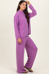 woman wearing a purple ribbed loungewear set with a mock neck top and wide-leg pants