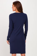 woman wearing a long sleeve navy ribbed dress, viewed from the back