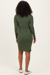 woman wearing a fitted green long sleeve dress, shown from the back, with a simple design and knee-length hem