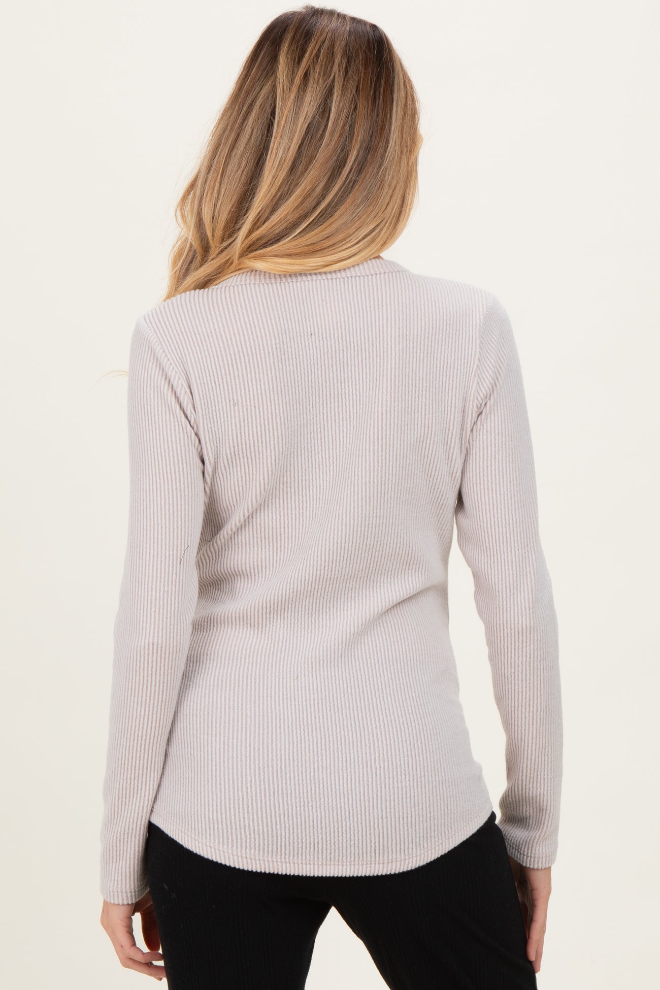 woman wearing a light gray ribbed long sleeve maternity top, showing the back view