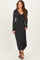 woman wearing a black long sleeve maxi dress with a v-neck and shimmery fabric
