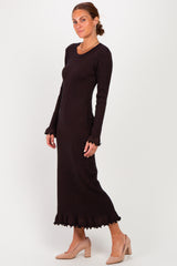 woman wearing a black long sleeve sweater dress with ruffled hem and a form-fitting silhouette