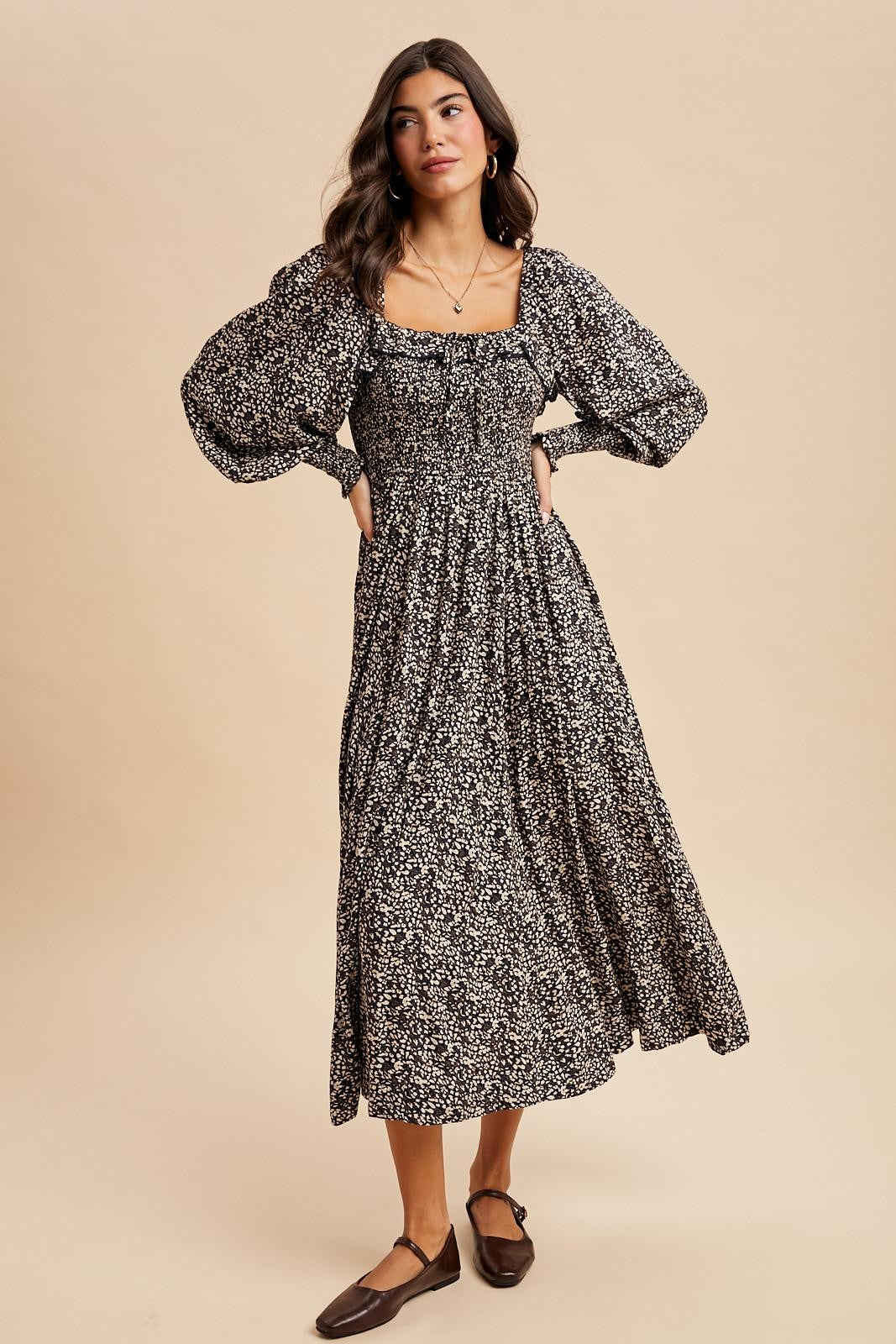 woman wearing a black and white floral maxi dress with puff sleeves and a square neckline