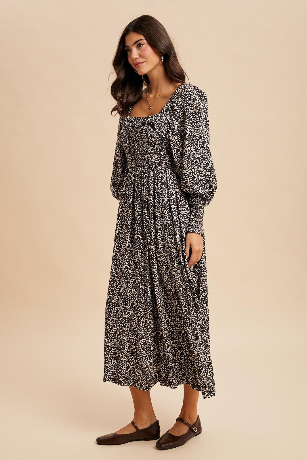 woman wearing a black and white floral long sleeve maxi dress with a square neckline and gathered waist