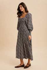 woman wearing a black and white floral long sleeve maxi dress with a square neckline and gathered waist