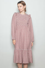 woman wearing a pink floral long sleeve dress with ruffle details and a tiered skirt