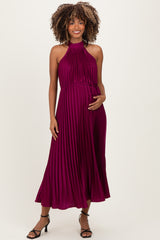woman wearing a burgundy pleated maternity dress with a halter neck and a baby bump visible