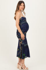 woman wearing a strapless navy floral maternity dress, highlighting her baby bump and styled with wedges.