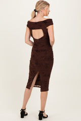woman wearing a brown ruched midi dress with an open back and side slit, styled with black block-heel sandals