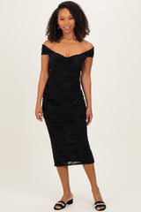 woman wearing a black off-the-shoulder midi dress with ruching and floral detailing