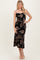 woman wearing a black floral print midi dress with spaghetti straps and a fitted silhouette