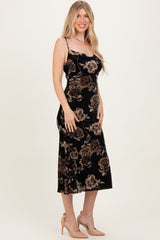 woman wearing a black floral velvet midi dress with spaghetti straps and a fitted silhouette