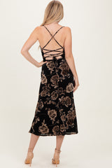 woman wearing a black floral midi dress with crisscross back detailing