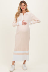 woman wearing a striped pastel pink and white long sleeve maternity dress, holding her baby bump