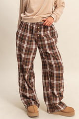 woman wearing brown and white plaid lounge pants with a relaxed fit and elastic waistband