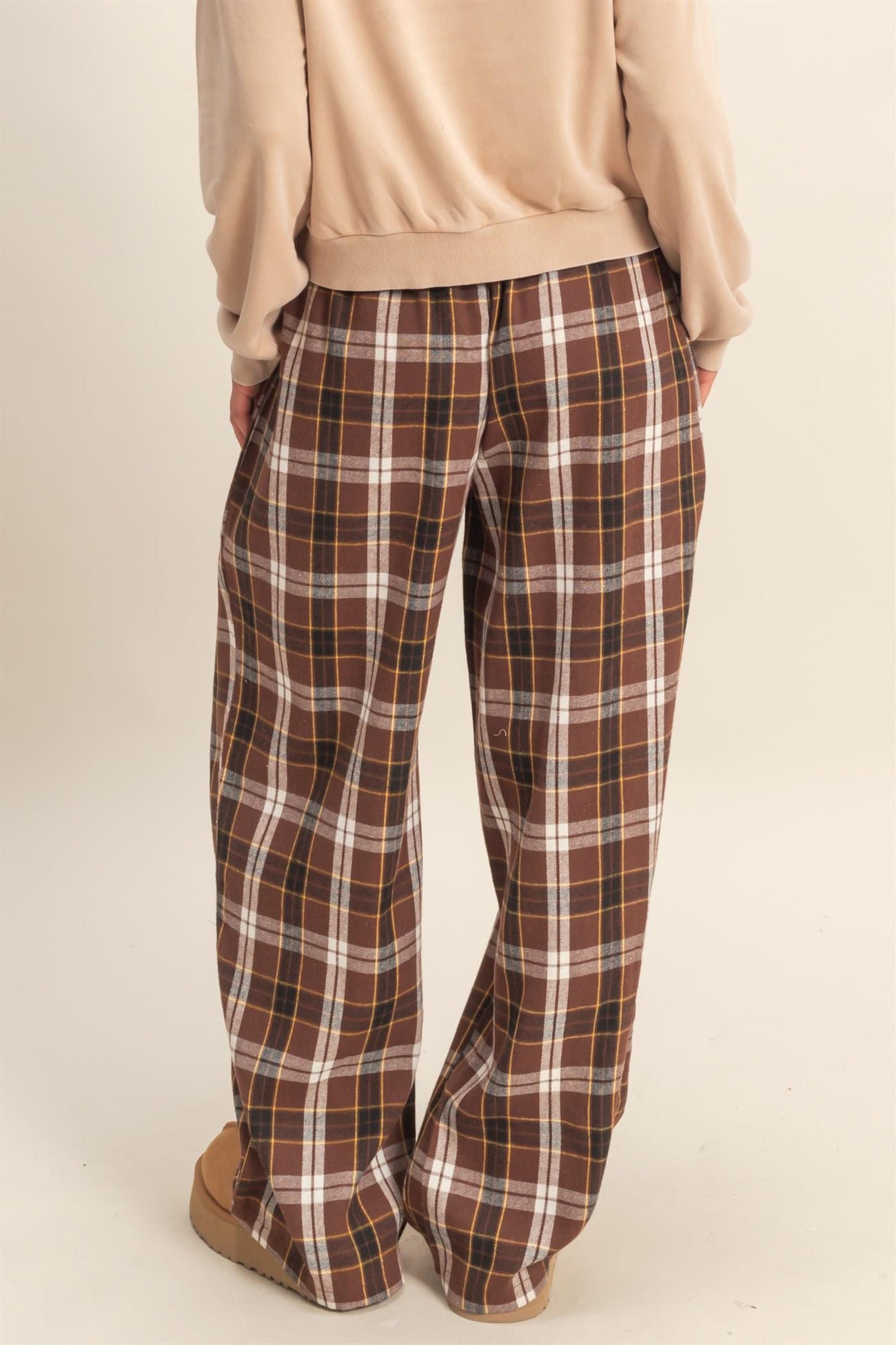 woman wearing brown and cream plaid wide-leg pants, view from the back