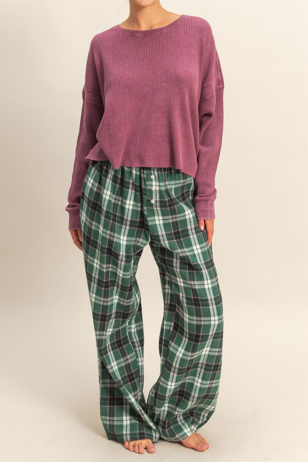 woman wearing a purple cropped ribbed sweater and green plaid wide-leg pajama pants