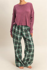 woman wearing a purple cropped ribbed sweater and green plaid wide-leg pajama pants