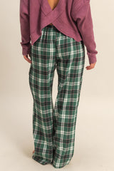 woman wearing a purple oversized sweater and green plaid wide-leg pants, viewed from the back