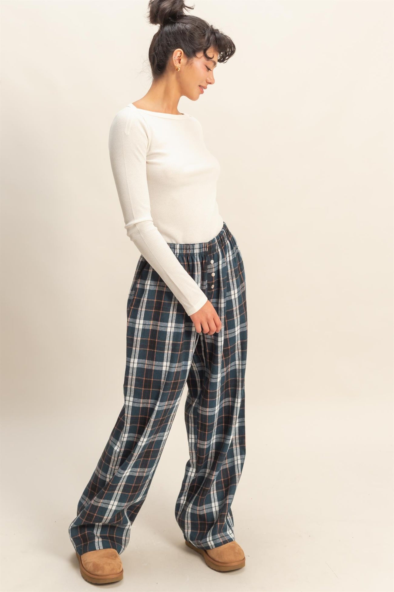 woman wearing a white long sleeve ribbed top and plaid wide-leg pants with side pockets