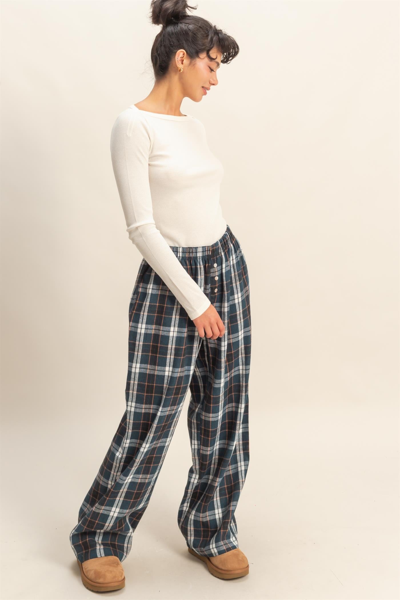 woman wearing a white long sleeve ribbed top and plaid wide-leg pants with side pockets