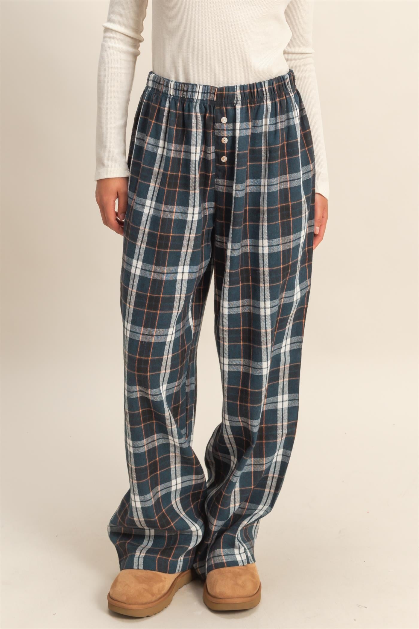 woman wearing navy and plaid lounge pants with a drawstring waist and button details
