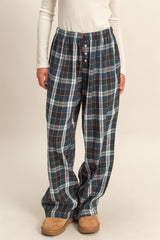 woman wearing navy and plaid lounge pants with a drawstring waist and button details