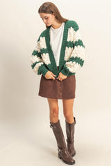 woman wearing a green and cream chunky knit cardigan with puff sleeves, styled with a brown suede mini skirt and knee-high boots