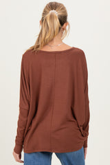 woman wearing a brown long sleeve maternity top with a relaxed fit, seen from the back