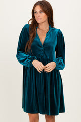 woman wearing a teal velvet long sleeve dress with a v-neck and gathered waist, styled with a relaxed fit
