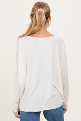 woman wearing a light beige maternity top with a relaxed fit and long sleeves, viewed from the back