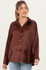 woman wearing a brown satin maternity button-up shirt with a relaxed fit and long sleeves