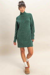 woman wearing a green knitted sweater dress with a high neck and long sleeves, styled with cozy footwear