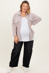 woman wearing a light pink maternity plus oversized button-up jacket over a white tank top and black baggy pants with a baby bump visible