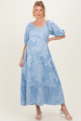 woman wearing a light blue floral maternity maxi dress with puff sleeves and a visible baby bump