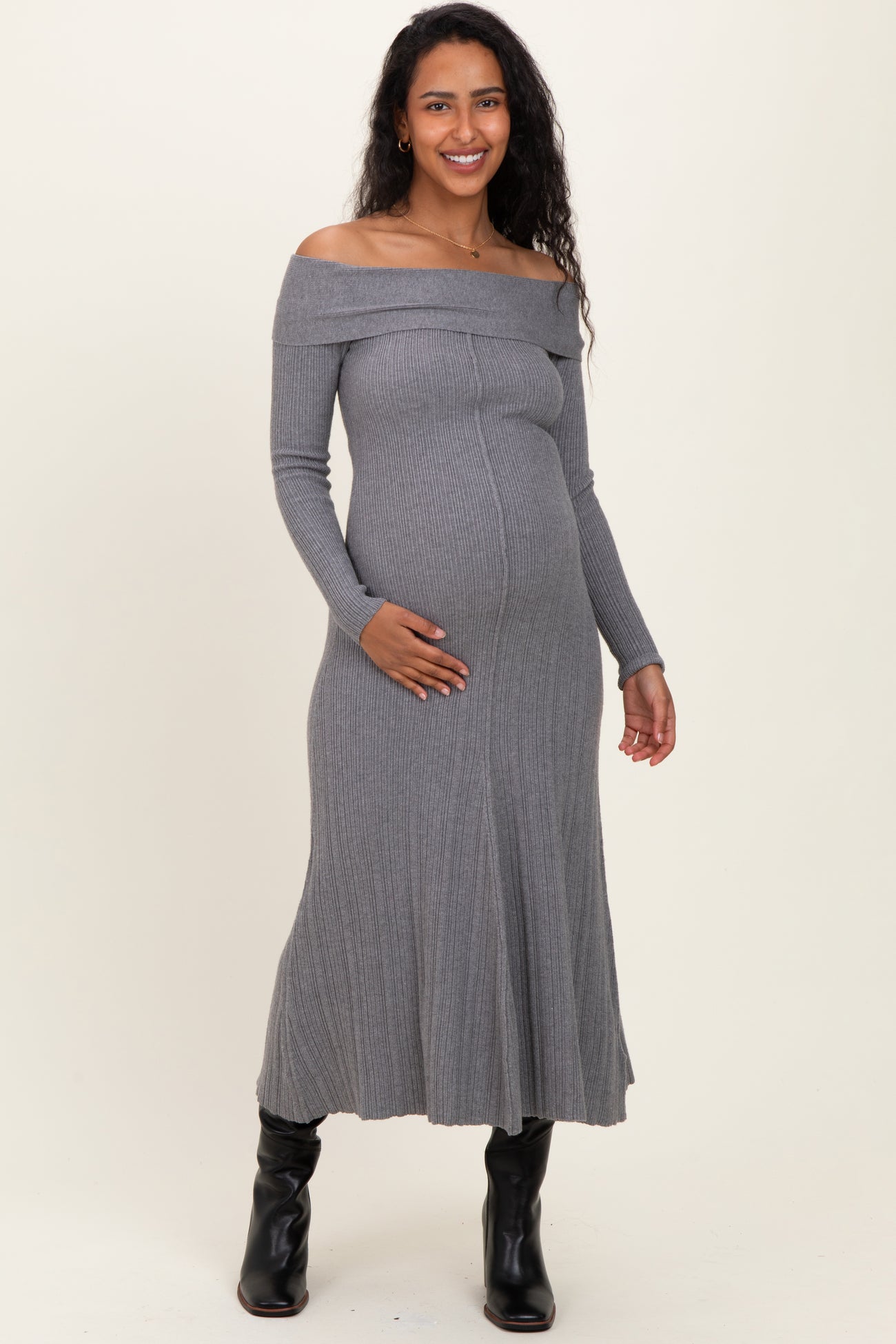 woman wearing a gray off-the-shoulder ribbed maternity dress and holding her baby bump