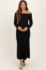 woman wearing a black off-the-shoulder ribbed maternity dress and holding her baby bump