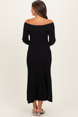 woman wearing a black off-the-shoulder ribbed maternity dress with long sleeves, view from the back
