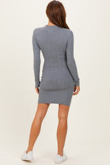 woman wearing a fitted gray ribbed long sleeve dress and white sneakers, viewed from the back