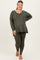 woman wearing a green maternity plus long sleeve top and matching leggings, showing her baby bump