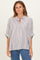 woman wearing a striped button-up shirt with rolled sleeves and relaxed fit, paired with blue jeans