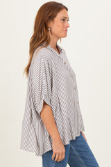 woman wearing a striped button-up oversized blouse with short sleeves and relaxed fit