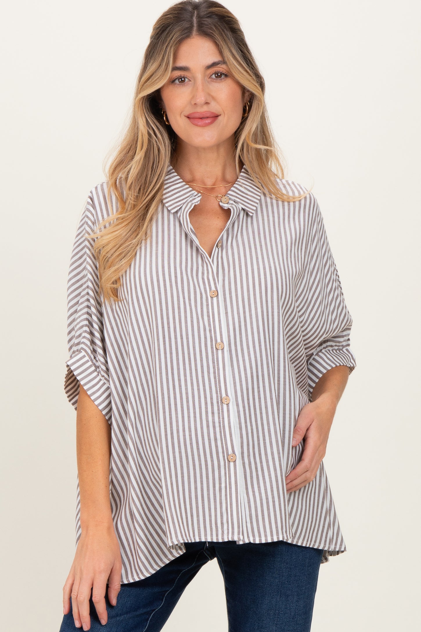 woman wearing a beige and white striped maternity shirt with a button-down front and short sleeves