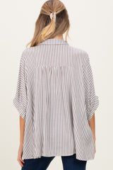 woman wearing a brown and cream striped maternity shirt with a loose fit and rolled sleeves, showing the back view