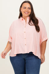 woman wearing a coral and white striped plus size button-up shirt with a relaxed fit and rolled sleeves
